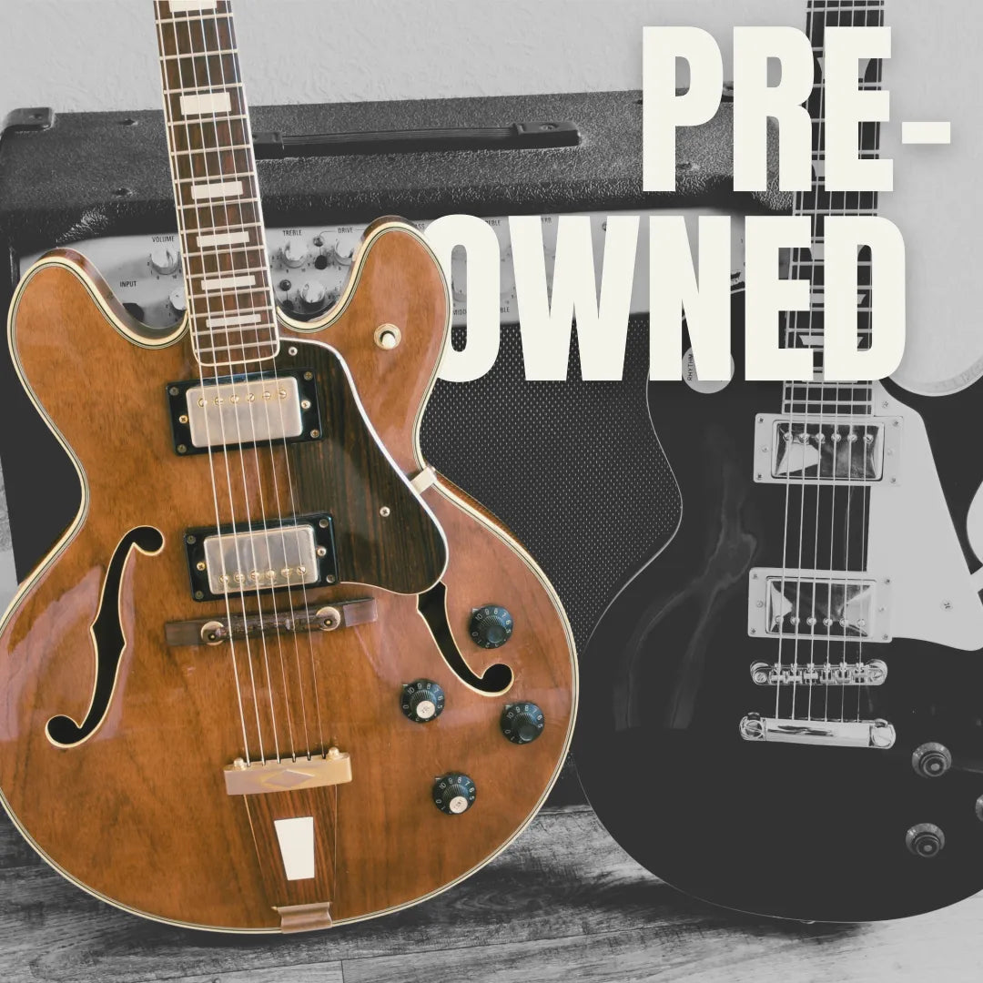 Vintage hollow-body and solid-body electric guitars leaning against a classic amplifier.