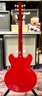 Full-length rear view of the guitar from headstock to body, showing the one-piece neck and a hang tag still attached to the tuners.