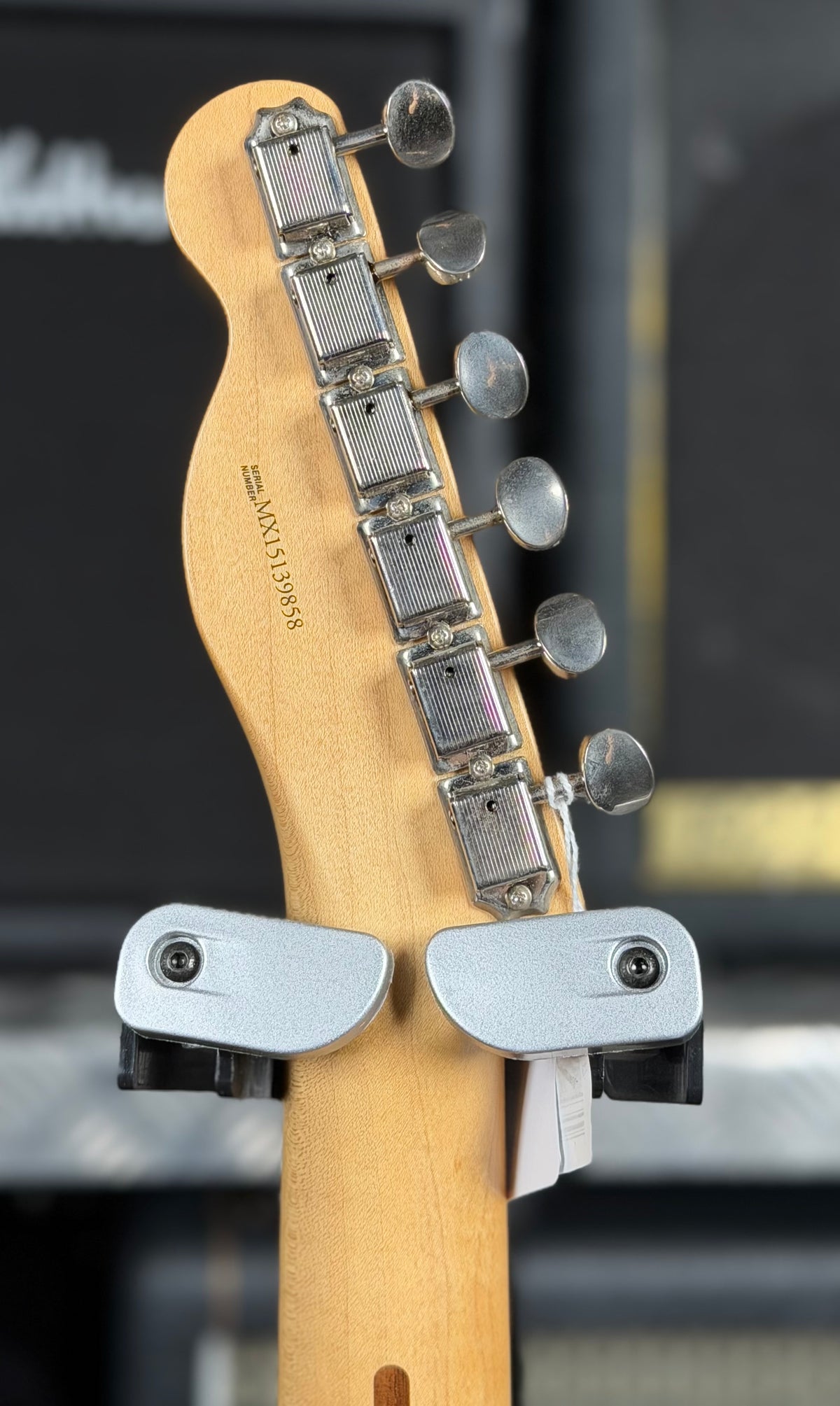 Close-up of the back of the headstock showing the printed serial number MX15139858 and vintage-style tuners.