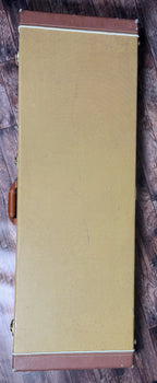 The included Fender tweed hard case, shown closed with its brown leather trim and handle.