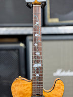 Close-up of the fretboard showing the abalone and mother-of-pearl rose-and-vine inlay running the length of the neck.