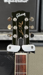 Close-up of the black headstock face showing the pearl Gibson logo, Les Paul Model script and nickel tuners.