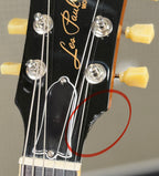 Close-up of the headstock showing a small chip in the finish along its lower edge, circled in red to highlight the flaw for this pre-owned listing.