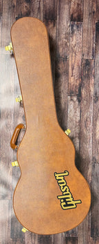 The included tan Gibson hardshell case, shown closed with its yellow Gibson logo and leather handle.
