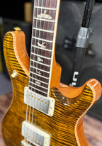 Close-up of the double cutaway and neck-body join, highlighting the bird inlays and the tightly figured tiger maple grain around the pickups.