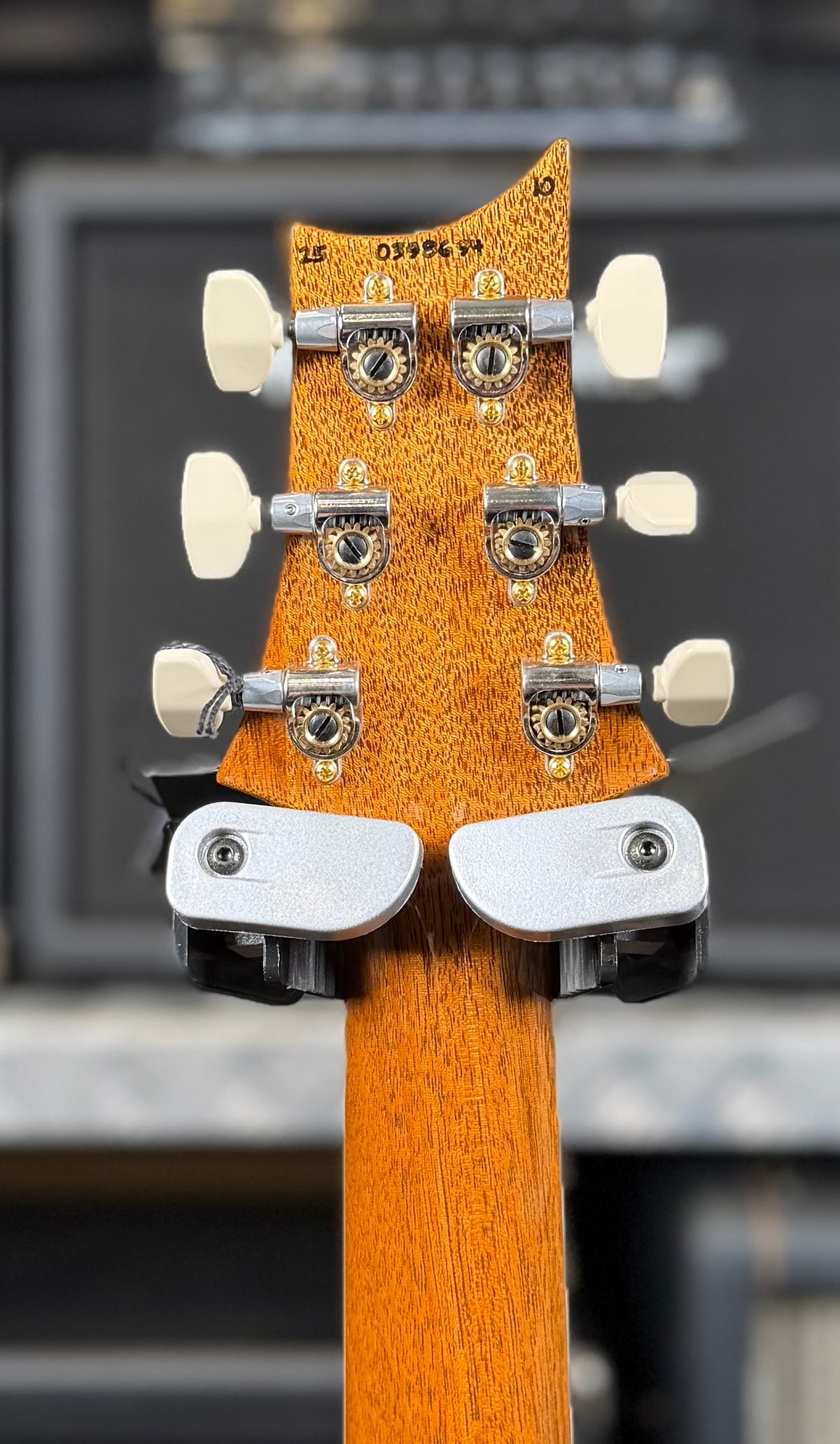 Rear of the headstock showing the mahogany finish, the handwritten factory serial number and cream-buttoned tuners.