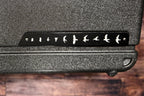 Close-up of the case's corner showing the PRS bird-in-flight logo plate on the textured case exterior.