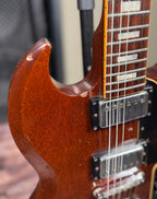 Close-up of the upper cutaway horn and neck joint of the Gibson SG Deluxe, showing a small chip in the finish at the point of the horn.