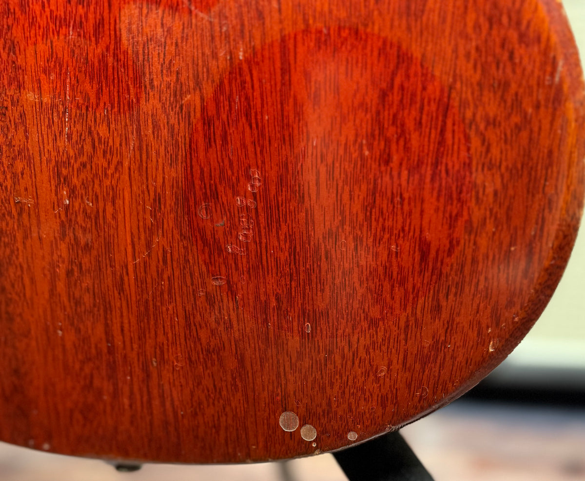 Extreme close-up of the back of the Gibson SG Deluxe body showing the mahogany wood grain along with small surface dents and blemishes.