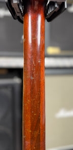 Close-up of the back of the neck on the Gibson SG Deluxe showing finish checking and wear consistent with the guitar's age.