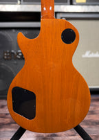 Full back view of the guitar body showing the satin mahogany finish, control cavity cover and toggle switch plate, with visible grain and a few faint handling marks.