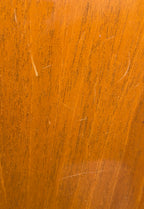 Extreme close-up of the mahogany back finish showing several fine surface scratches and light handling marks.