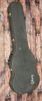 Closed black Gibson hardshell case for the SG Deluxe, viewed from above and resting on a wooden floor.