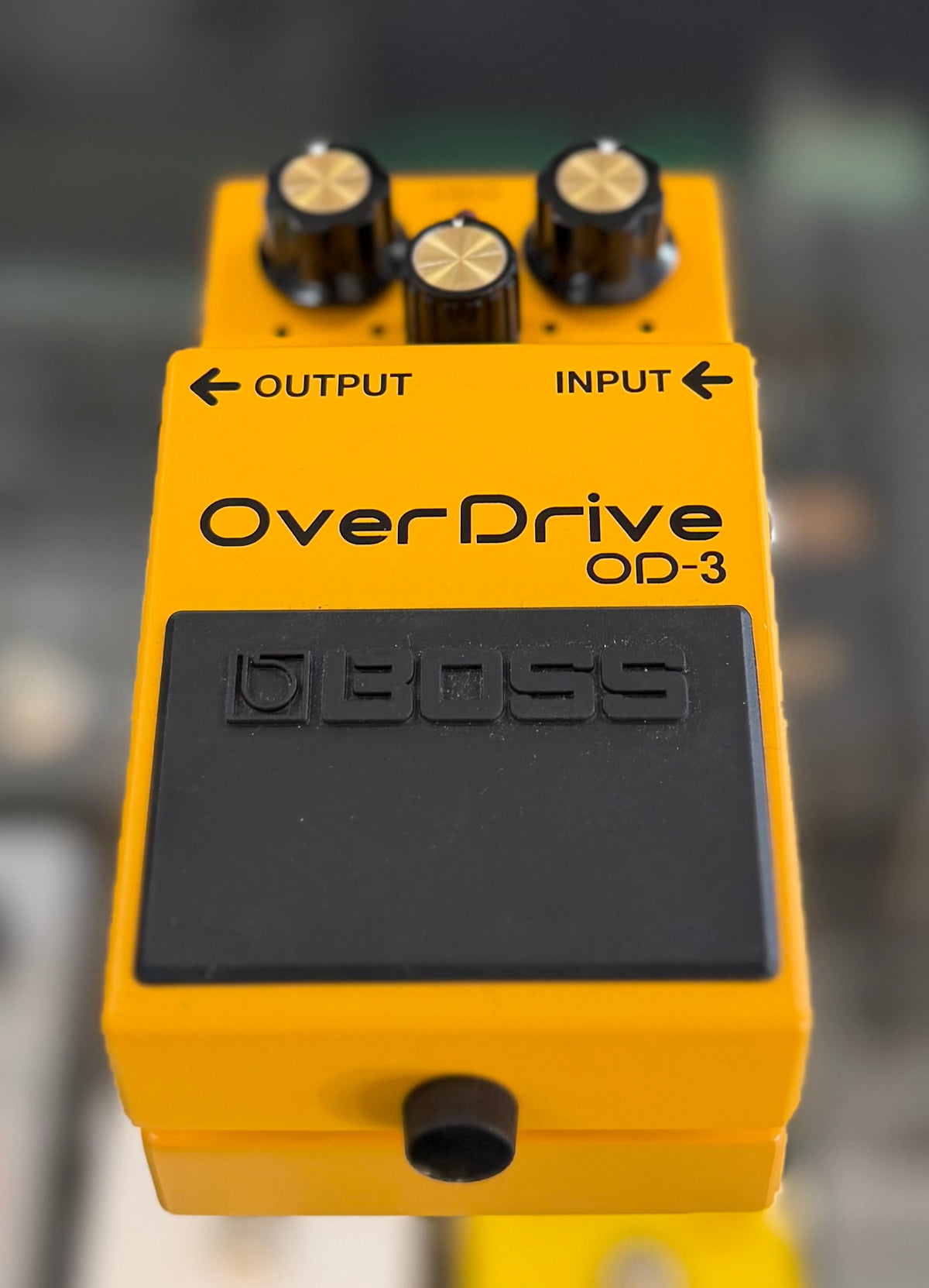 Top-down view of the full pedal and footswitch, showing the yellow casing and control layout in clean, near-mint condition.