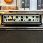 Front panel of the Ashdown ABM 500 EVO-III bass amp head, showing the VU meter and the input, valve drive, bass, middle, treble, compression and sub-harmonics controls, sitting on top of a speaker cabinet.