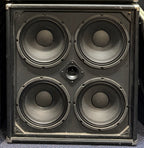 Front of the Ashdown 4x10 bass cabinet with the grille removed, showing the four exposed 10 inch speakers and centre tweeter, with visible scuffing and wear to the cabinet corners.